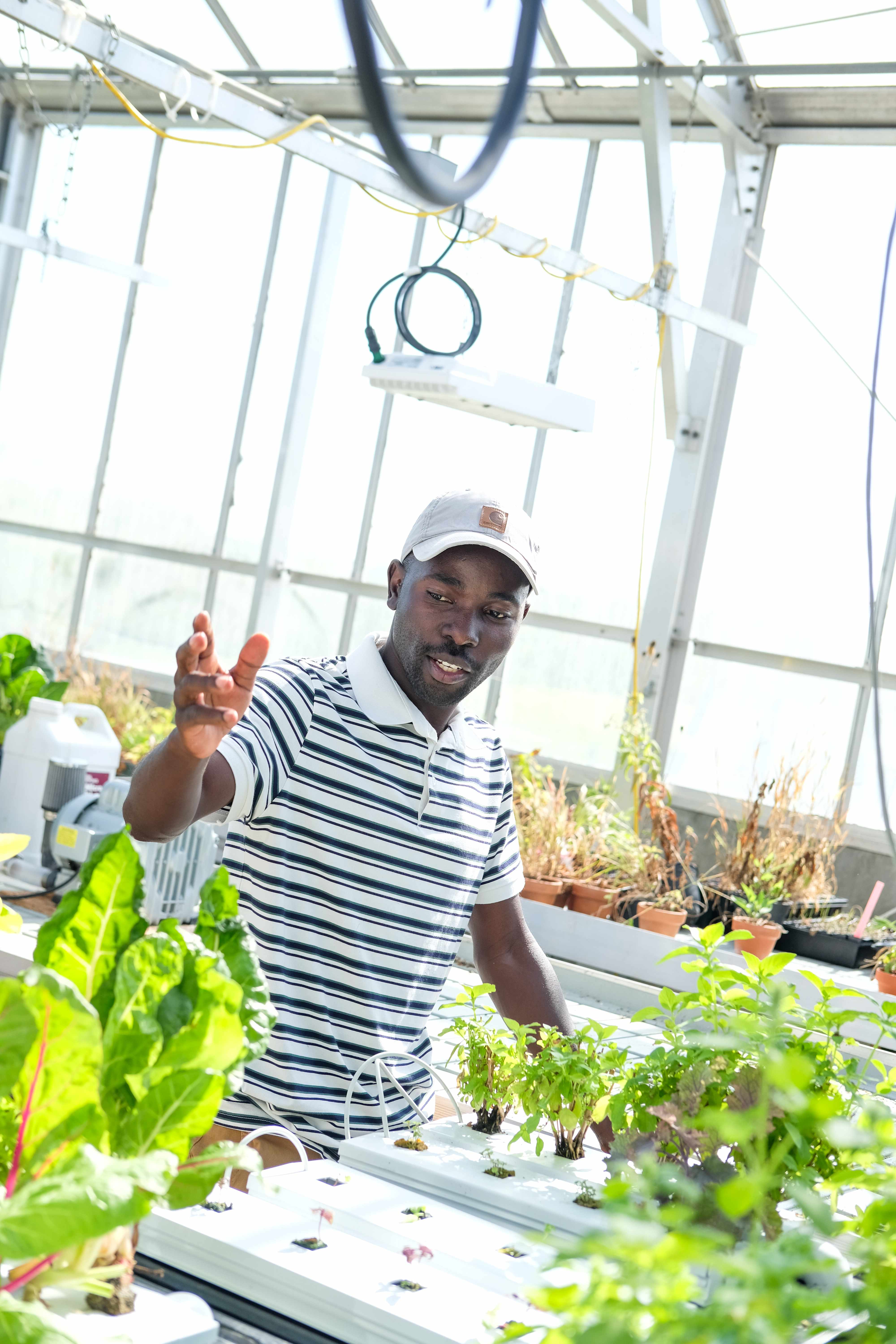 Arnold Katende instructing cohort in a greenhouse